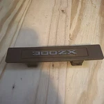 1984-89 Nissan 300zx Center Dash Emblem -- Oem Pn--- 96948 01p00 Exc-tan. Fixed Price $10.00.